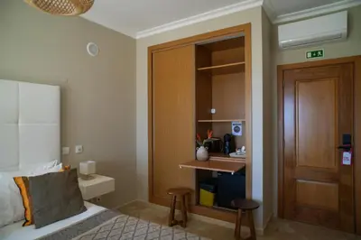 a hotel room with a bed and a sink at Arrifana Destination Suites in Aljezur