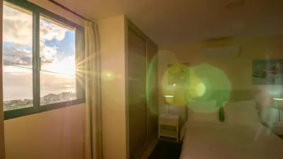 a bedroom with a bed and a large window at Refugio do Sol - Madeira Inn Group in Calheta