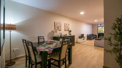 a dining room and living room with a table and chairs at Refugio do Sol - Madeira Inn Group in Calheta