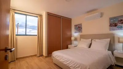 a bedroom with a white bed and a window at Refugio do Sol - Madeira Inn Group in Calheta