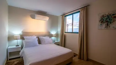 a bedroom with a white bed and a window at Refugio do Sol - Madeira Inn Group in Calheta