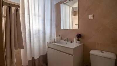a bathroom with a sink and a toilet and a mirror at Refugio do Sol - Madeira Inn Group in Calheta