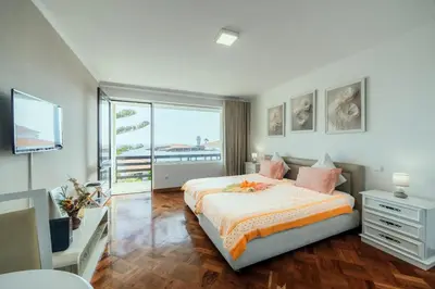 a bedroom with a bed and a large window at Studio Oceano in Caniço