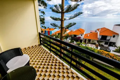 a balcony with a view of the ocean and houses at Studio Oceano in Caniço