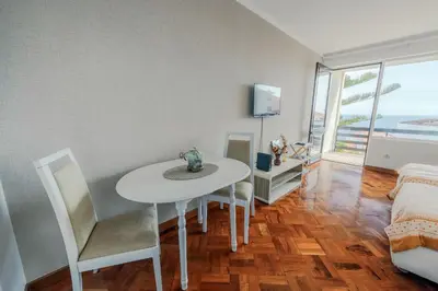 a dining room with a white table and chairs at Studio Oceano in Caniço