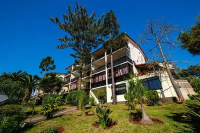 an apartment building with trees in front of it at Studio Oceano in Caniço