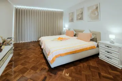 a bedroom with a large bed with a dresser at Studio Oceano in Caniço