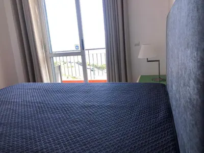 a bedroom with a bed and a large window at Em casa longe de casa, tão bom! in Gaula