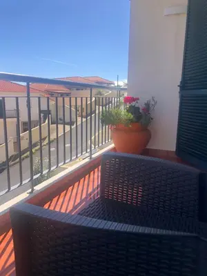 a balcony with a bench and a pot of flowers at Em casa longe de casa, tão bom! in Gaula