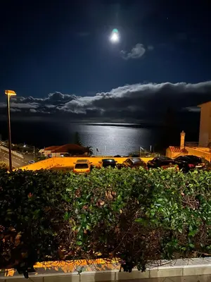 a full moon over the water with cars parked at Em casa longe de casa, tão bom! in Gaula