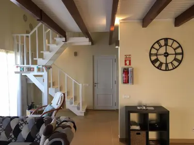 a living room with a couch and a clock on the wall at Villa Atlantis in Calheta