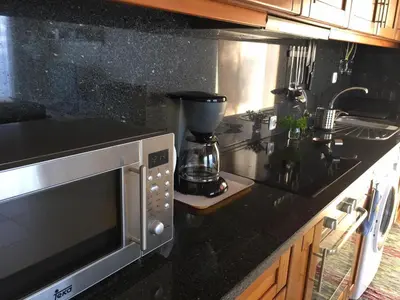 a kitchen with a microwave and a counter top at Villa Atlantis in Calheta