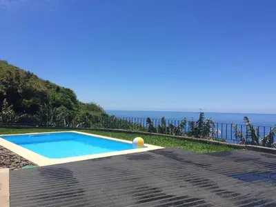 a swimming pool with the ocean in the background at Villa Atlantis in Calheta
