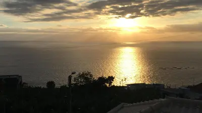 a sunset over the ocean with a bridge in the sky at Villa Atlantis in Calheta