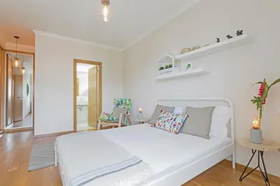 a white bedroom with a bed and a chair at Jasmineiro II by An Island Apart in Funchal