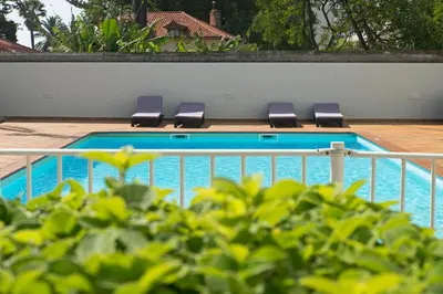 a swimming pool with lounge chairs next to a fence at Jasmineiro II by An Island Apart in Funchal