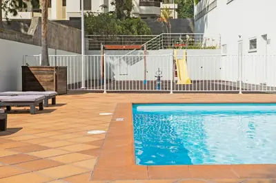 a swimming pool with a slide in a building at Jasmineiro II by An Island Apart in Funchal