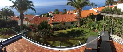 arial view of a house with palm trees and the ocean at Casa Matschinegg Madeira in Caniço