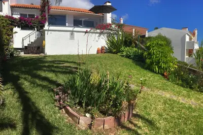a yard with a house and a garden with plants at Casa Matschinegg Madeira in Caniço