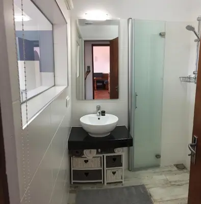 a bathroom with a sink and a glass shower at Casa Matschinegg Madeira in Caniço