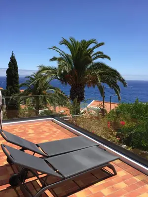 a patio with a chair and a view of the ocean at Casa Matschinegg Madeira in Caniço