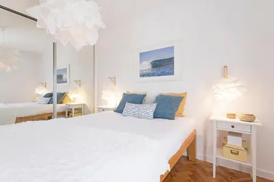 a bedroom with two beds and a mirror at Pina I by An Island Apart in Funchal