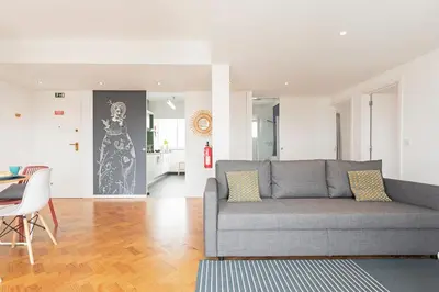 a living room with a gray couch and a table at Pina I by An Island Apart in Funchal
