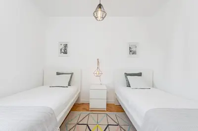 two beds in a room with white walls at Pina I by An Island Apart in Funchal