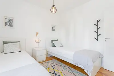 two beds in a room with white walls at Pina I by An Island Apart in Funchal