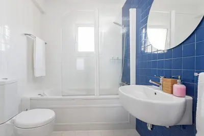 a bathroom with a white toilet and a sink at Pina I by An Island Apart in Funchal