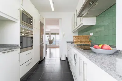 a kitchen with white cabinets and a bowl of fruit on the counter at Pina I by An Island Apart in Funchal