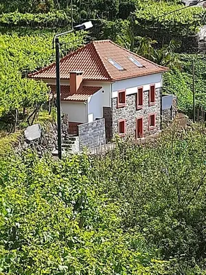 a small white house with a red roof at Casa da Ribeira in São Vicente