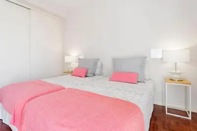 a bedroom with a large bed with pink pillows at Casa Branca by Homie in Funchal