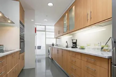 a large kitchen with wooden cabinets and stainless steel appliances at Casa Branca by Homie in Funchal