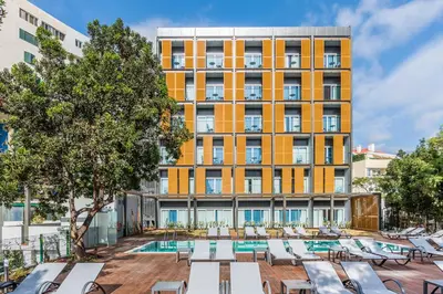 a hotel with a pool and lounge chairs in front of a building at Pestana Casino Studios in Funchal
