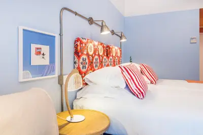 a bedroom with a bed with a lamp and a table at Pestana Casino Studios in Funchal