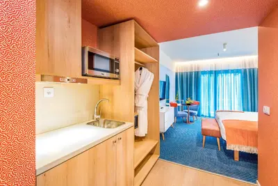 a kitchen with a sink and a room with a bed at Pestana Casino Studios in Funchal