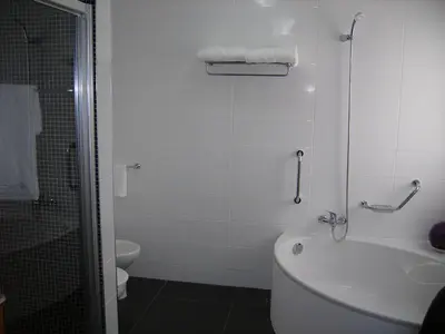 a bathroom with a tub and a toilet and a sink at Vila Faia in Caniço