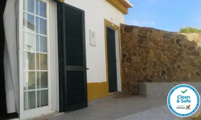 a house with a door and a stone wall at Casa Alfarroba in Barão de São Miguel