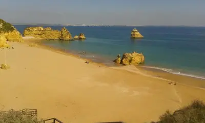 a beach with some rocks in the water at Casa Alfarroba in Barão de São Miguel