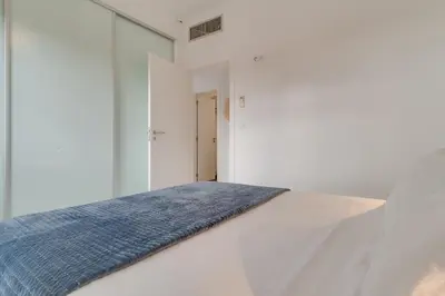 a bed with a blue blanket on top of it at Lazareto Apartment by Holiday Rental Madeira in Funchal