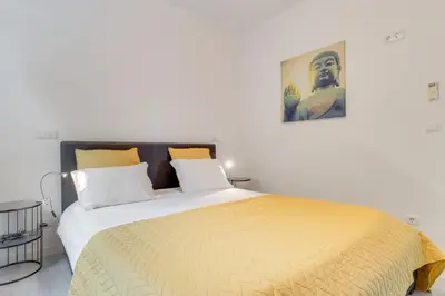 a bedroom with a large bed with a yellow blanket at Lazareto Apartment by Holiday Rental Madeira in Funchal