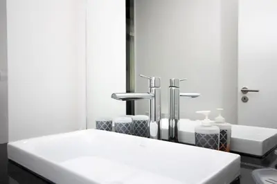 a bathroom with two sinks and two faucets at Lazareto Apartment by Holiday Rental Madeira in Funchal