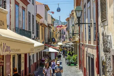 a group of people walking down a street with buildings at Lazareto Apartment by Holiday Rental Madeira in Funchal