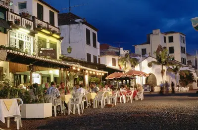 a group of people sitting at tables outside a restaurant at Lazareto Apartment by Holiday Rental Madeira in Funchal