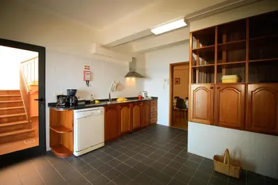 a kitchen with wooden cabinets and a white refrigerator at Paradise Ocean View by AnaLodges in Porto Moniz