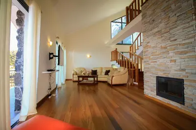 a living room with a fireplace and a stone wall at Paradise Ocean View by AnaLodges in Porto Moniz