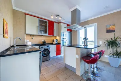 a kitchen with red cabinets and a sink and a stove at Your Villa Algarve Private pool 5 min walk to beach in Burgau