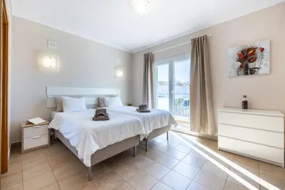 a bedroom with a bed and a large window at Your Villa Algarve Private pool 5 min walk to beach in Burgau