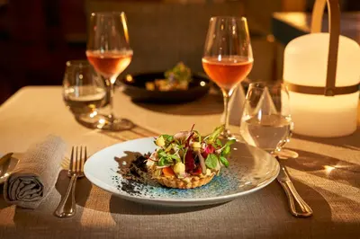 a dining room with two tables with wine glasses at The Residence Porto Mare - PortoBay in Funchal
